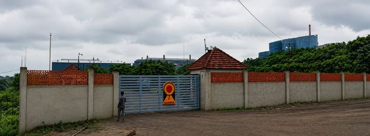 The approach to the works at Sarandi: boundary wall and main gate, with the plant on the ridge behind