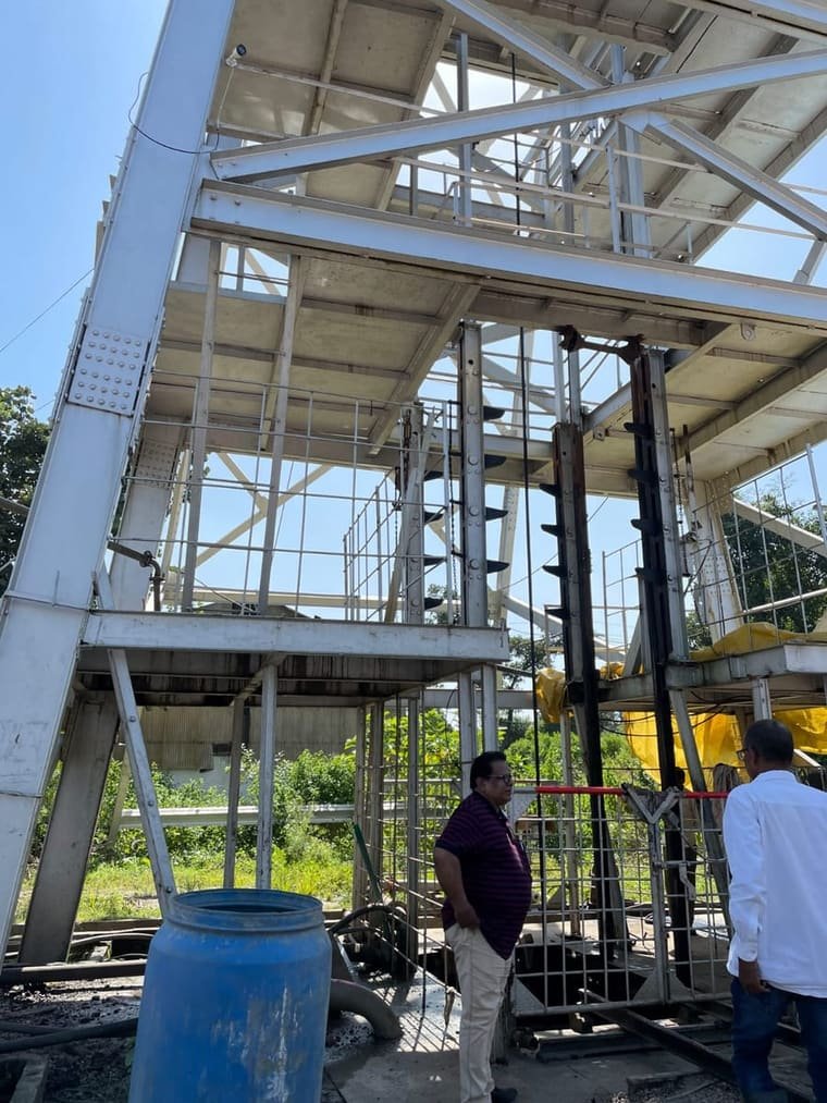 Structural steelwork inside the plant, with workers at the base